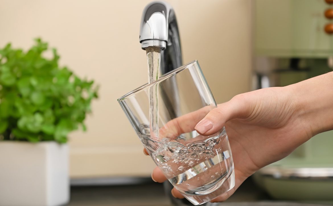 Woman,Filling,Glass,With,Fresh,Water,From,Kitchen,Faucet