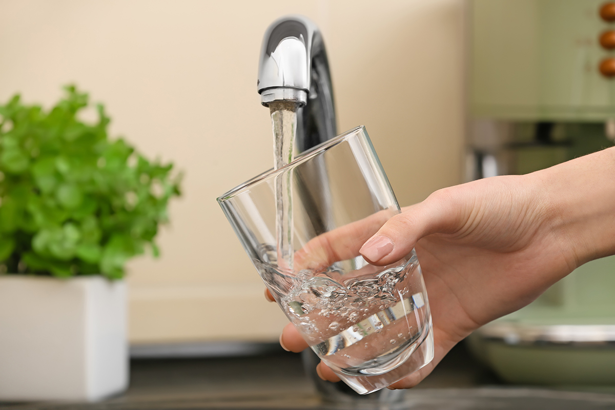 Woman,Filling,Glass,With,Fresh,Water,From,Kitchen,Faucet